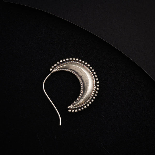 a pair of earrings with beads on a black surface