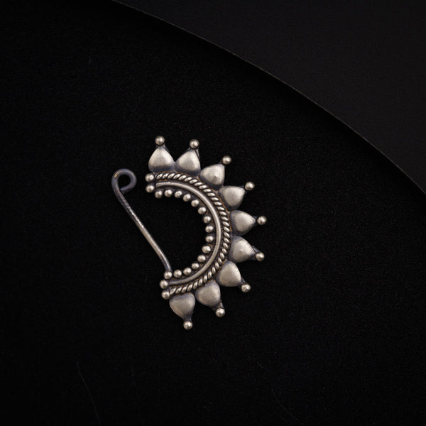 a close up of a brooch on a black surface