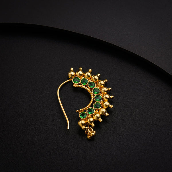 a pair of green and gold earrings on a black surface