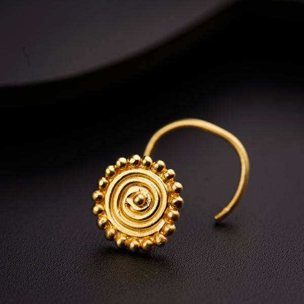 a pair of gold earrings on a black surface