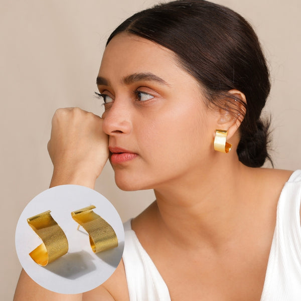 woman wearing gold fold earrings