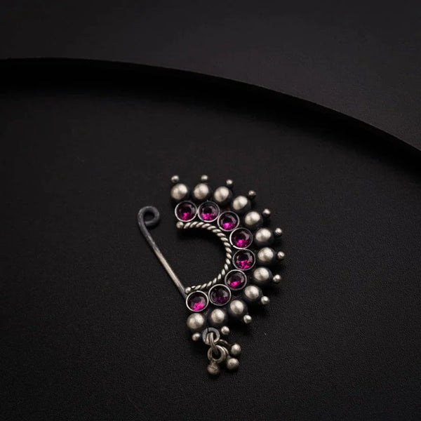 a close up of a brooch on a black surface