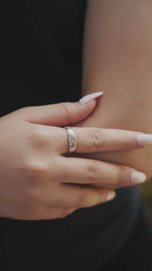 Silver band ring on finger