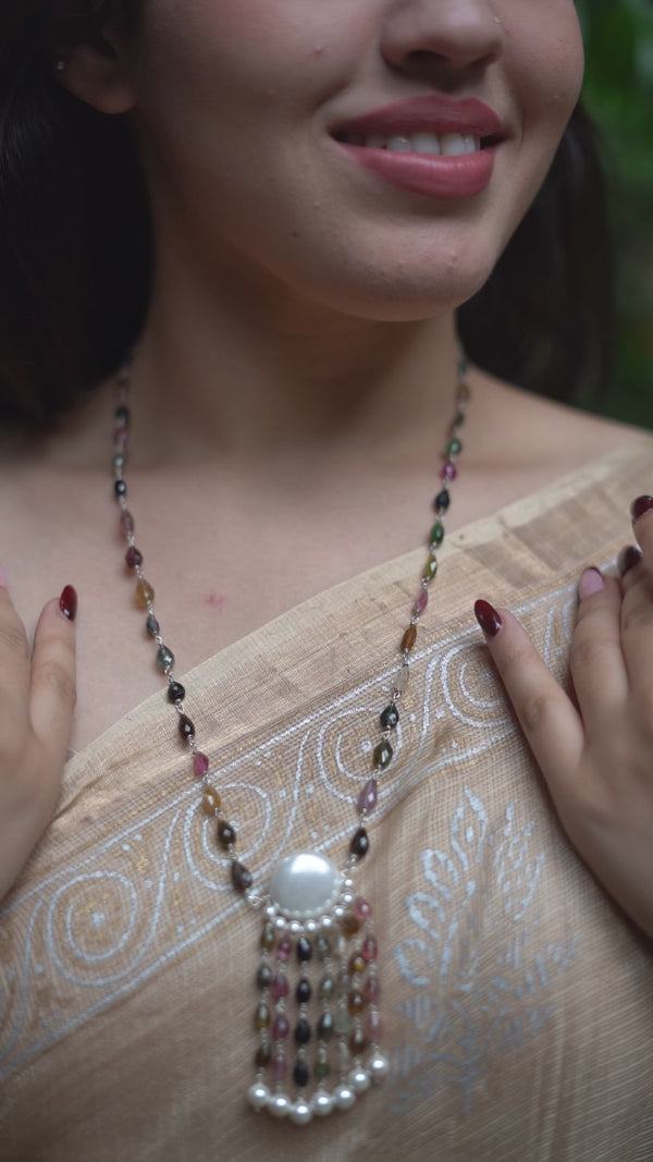 Woman wearing colorful tourmaline and Swarovski pearl necklace