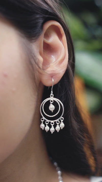 a close up of a person wearing a pair of earrings