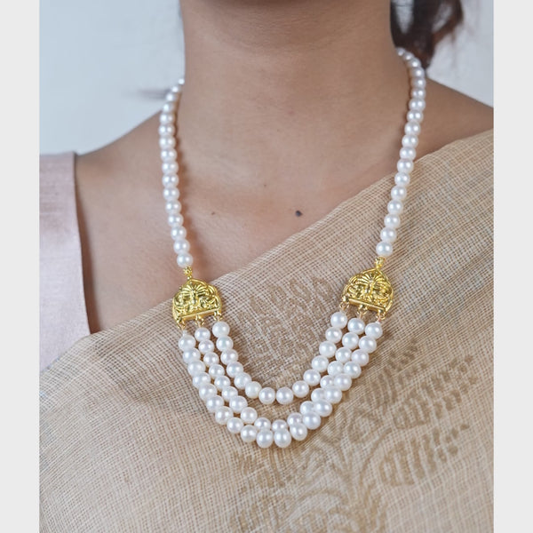Close-up of pearl necklace with gold embellishments and tassel