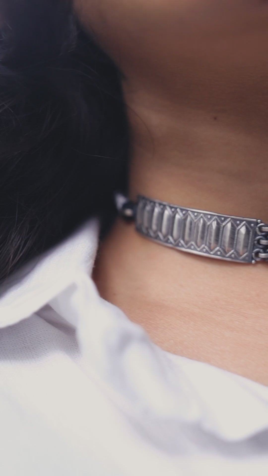 a close up of a person wearing a silver bracelet