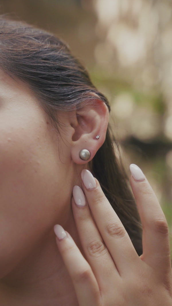 Silver oxidized small dome earrings on ear