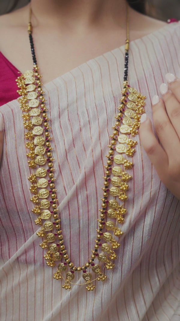 Model wearing gold Mango Saaj with black spinels and red stones