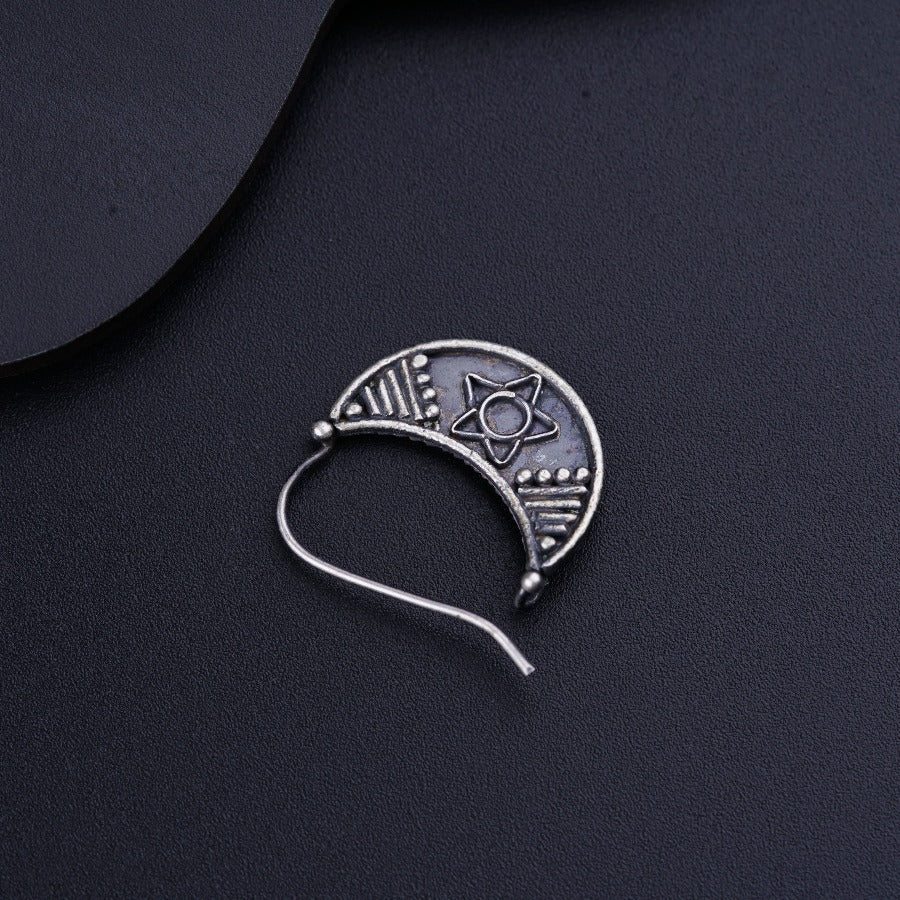 a silver brooch with a design on it