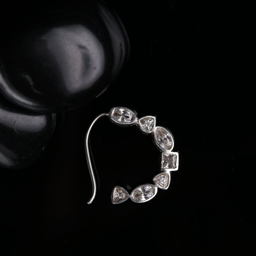 a pair of earrings sitting on top of a black surface