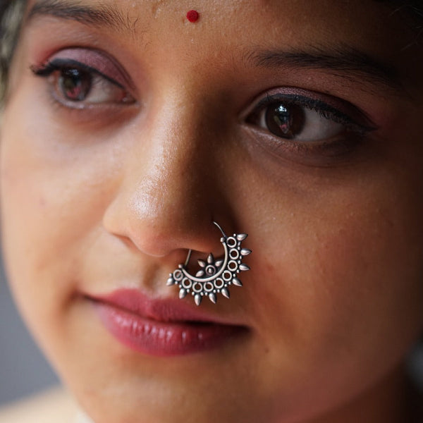 a close up of a woman with a nose ring