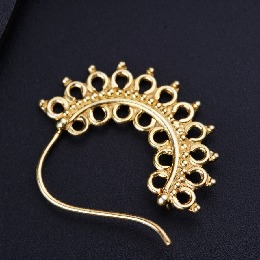 a gold brooch on a black surface