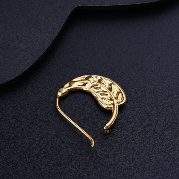 a gold brooch sitting on top of a black surface