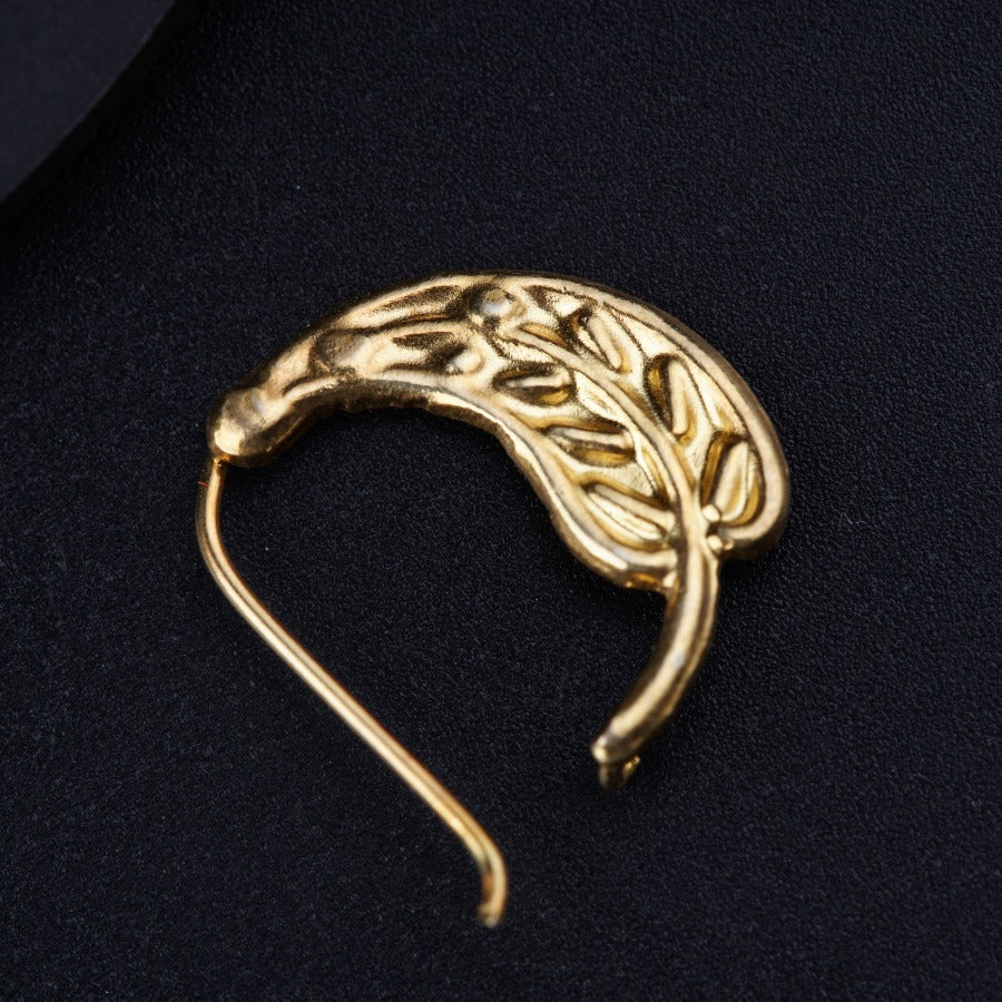 a gold brooch with a leaf design on it