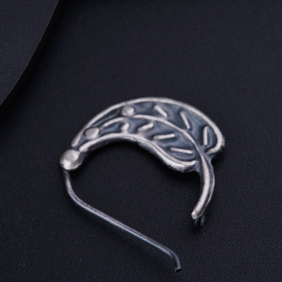 a silver brooch with a leaf design on it