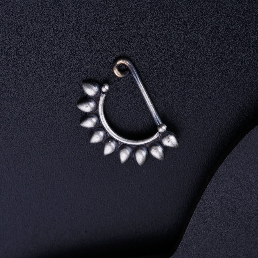 a close up of a pair of piercings on a black surface