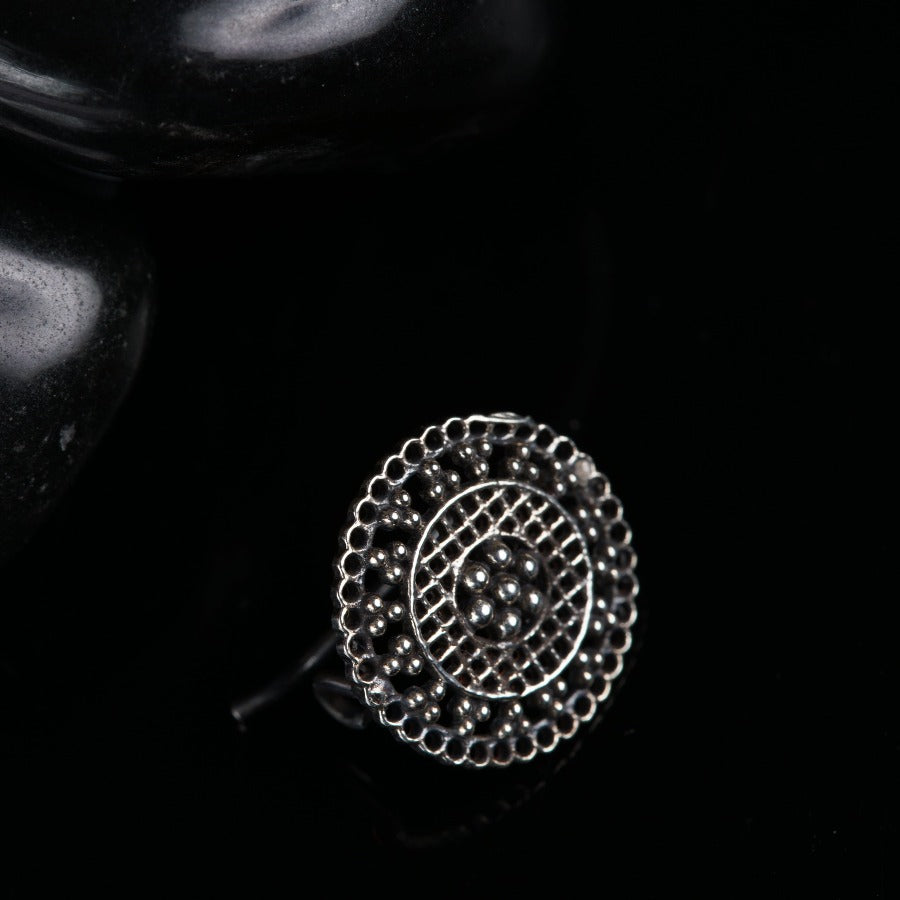 a silver ring sitting on top of a black surface