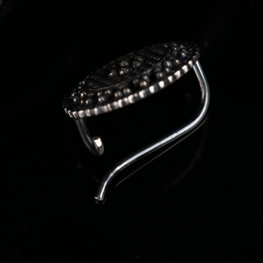 a silver ring with a black background