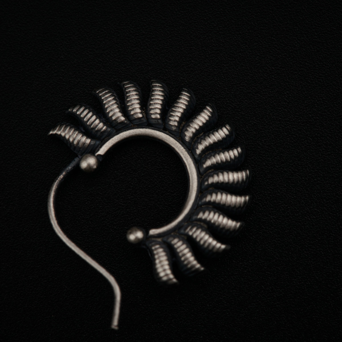 a pair of metal ear buds on a black surface