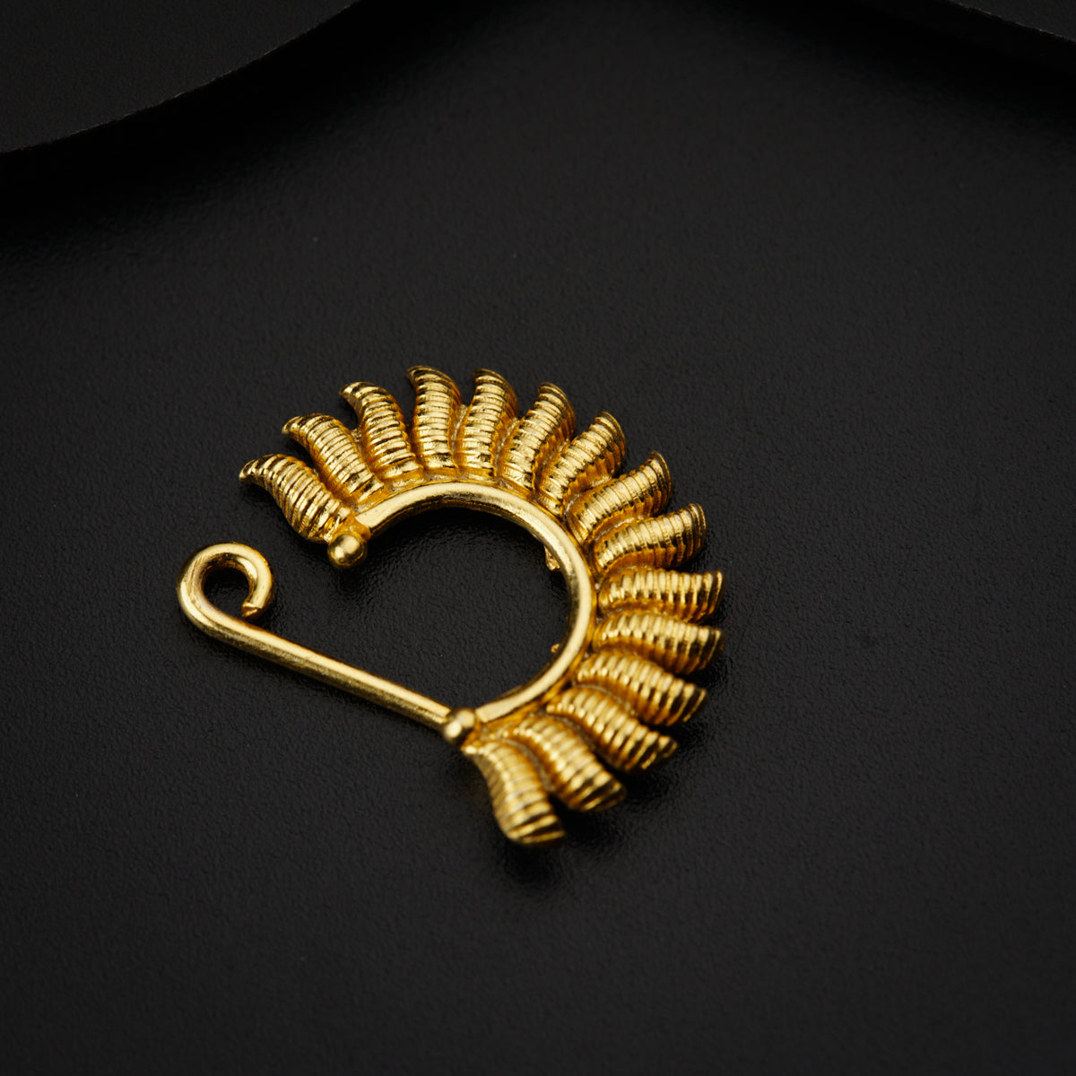 a gold brooch with a spiral design on it