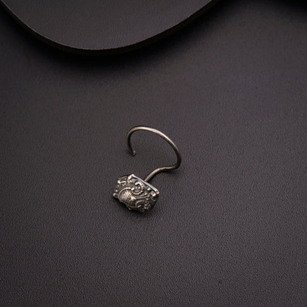 a pair of silver earrings sitting on top of a table
