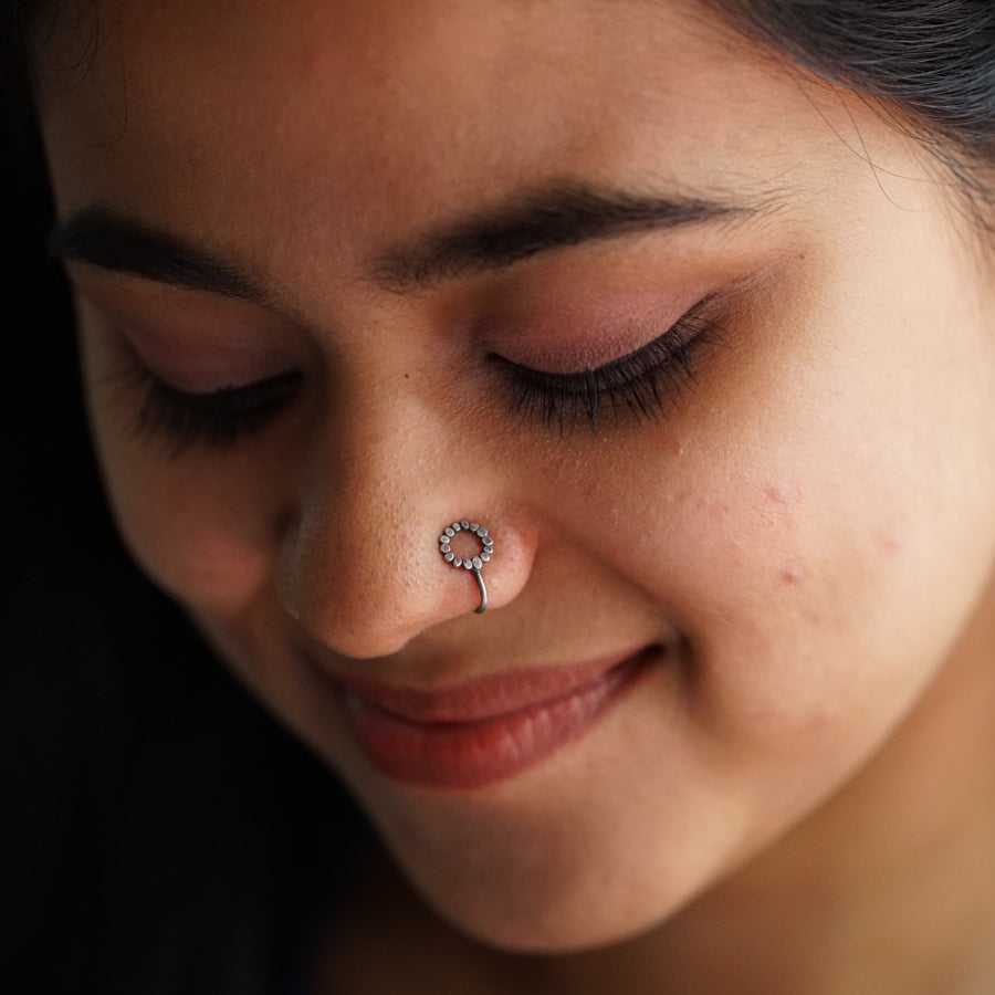 a close up of a woman with a nose piercing