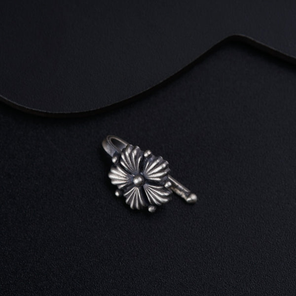a pair of earrings sitting on top of a black surface