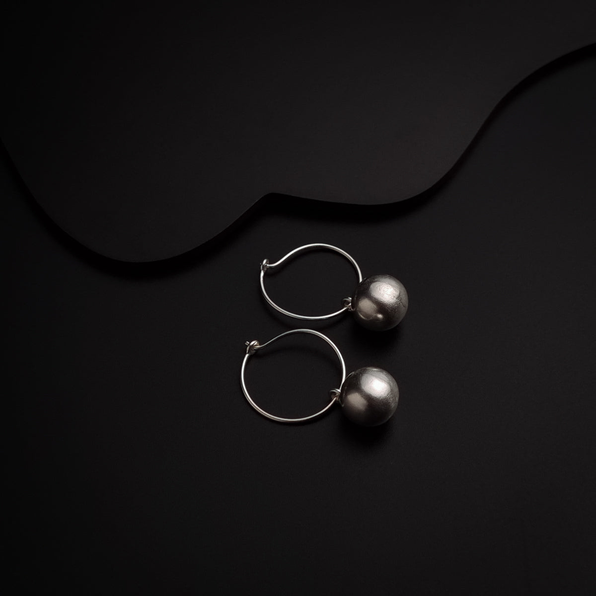 a pair of hoop earrings on a black background