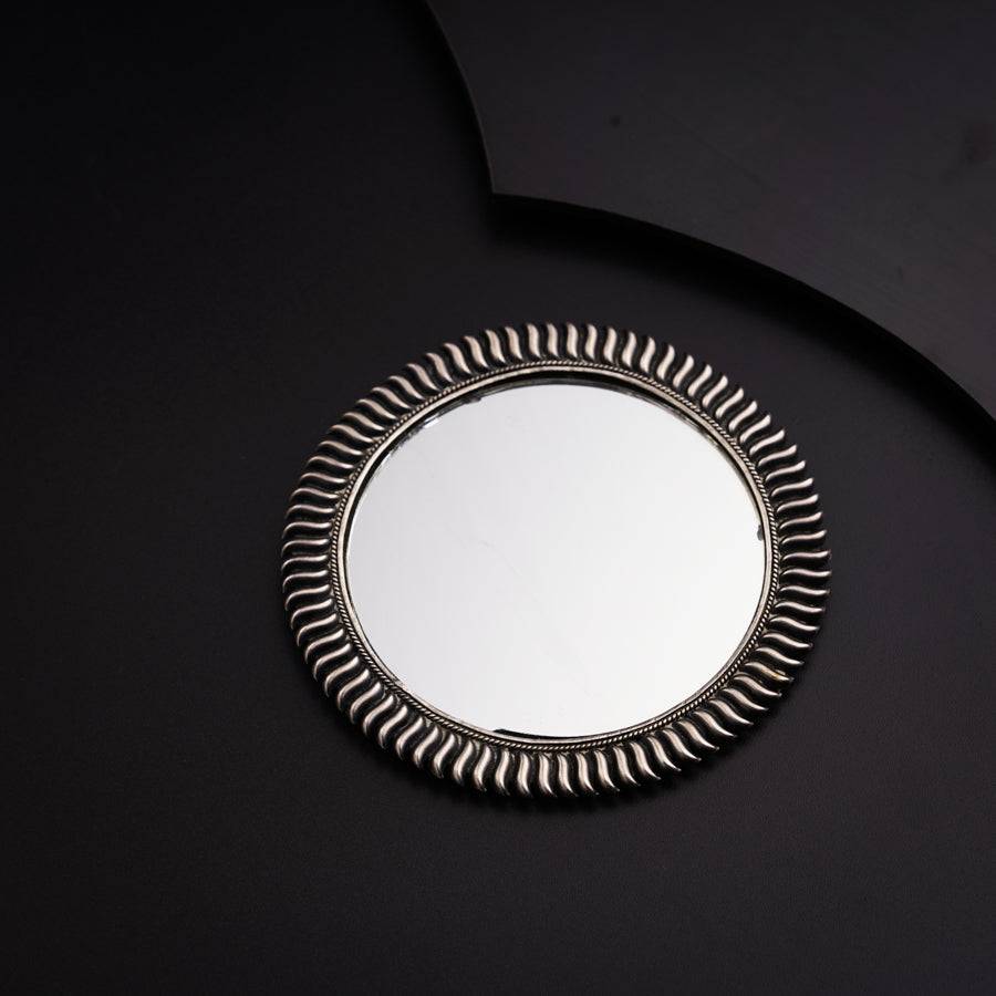 a round mirror sitting on top of a black table