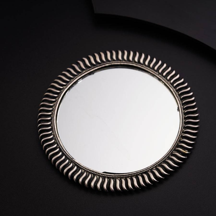 a round mirror sitting on top of a black table