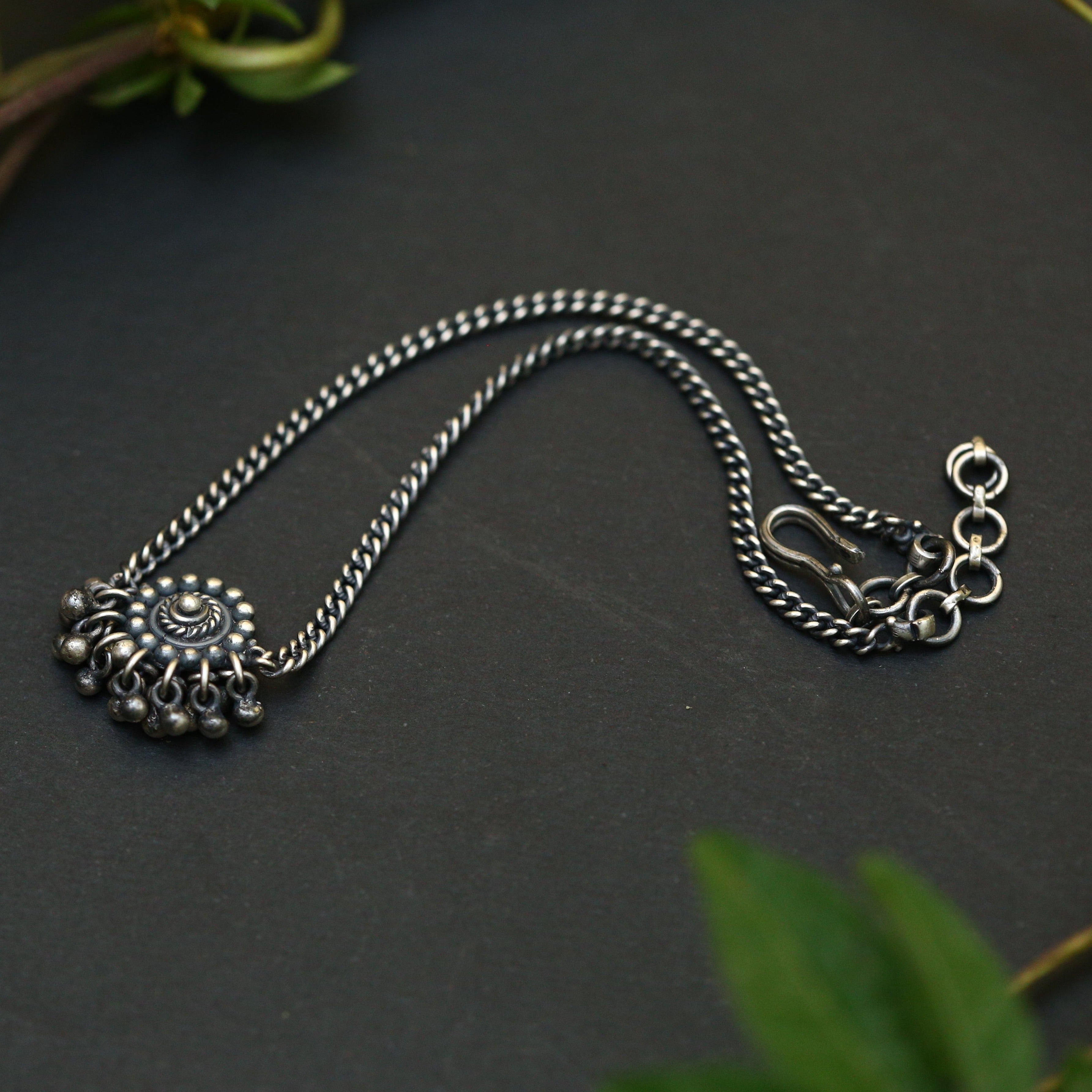 a silver chain with a flower on it