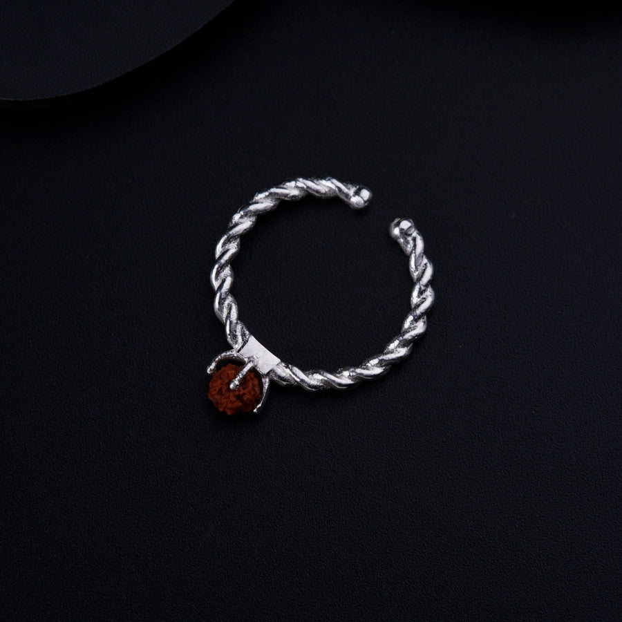 a silver rope bracelet with a red stone charm