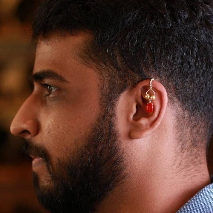 a close up of a man wearing a pair of ear piercings