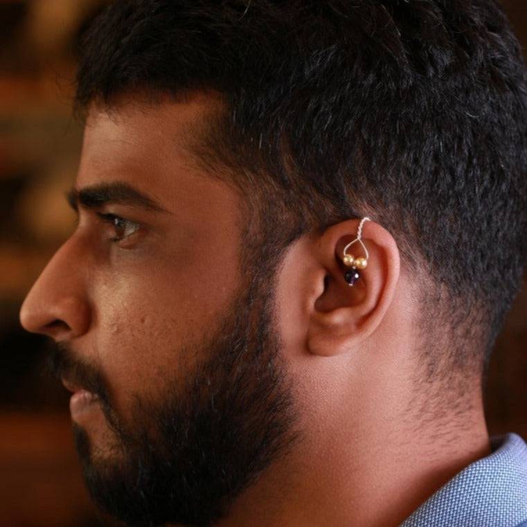 a close up of a man wearing a pair of ear piercings