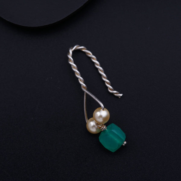 a necklace with pearls and a green bead