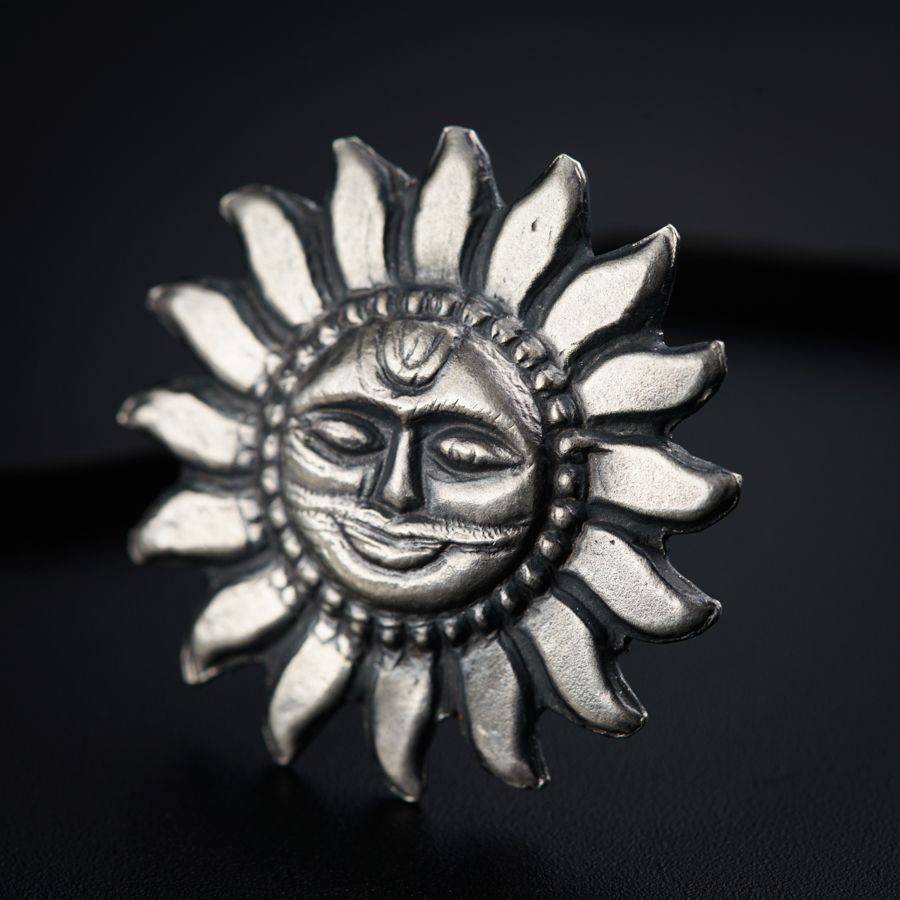 a silver sun ring with a face on it