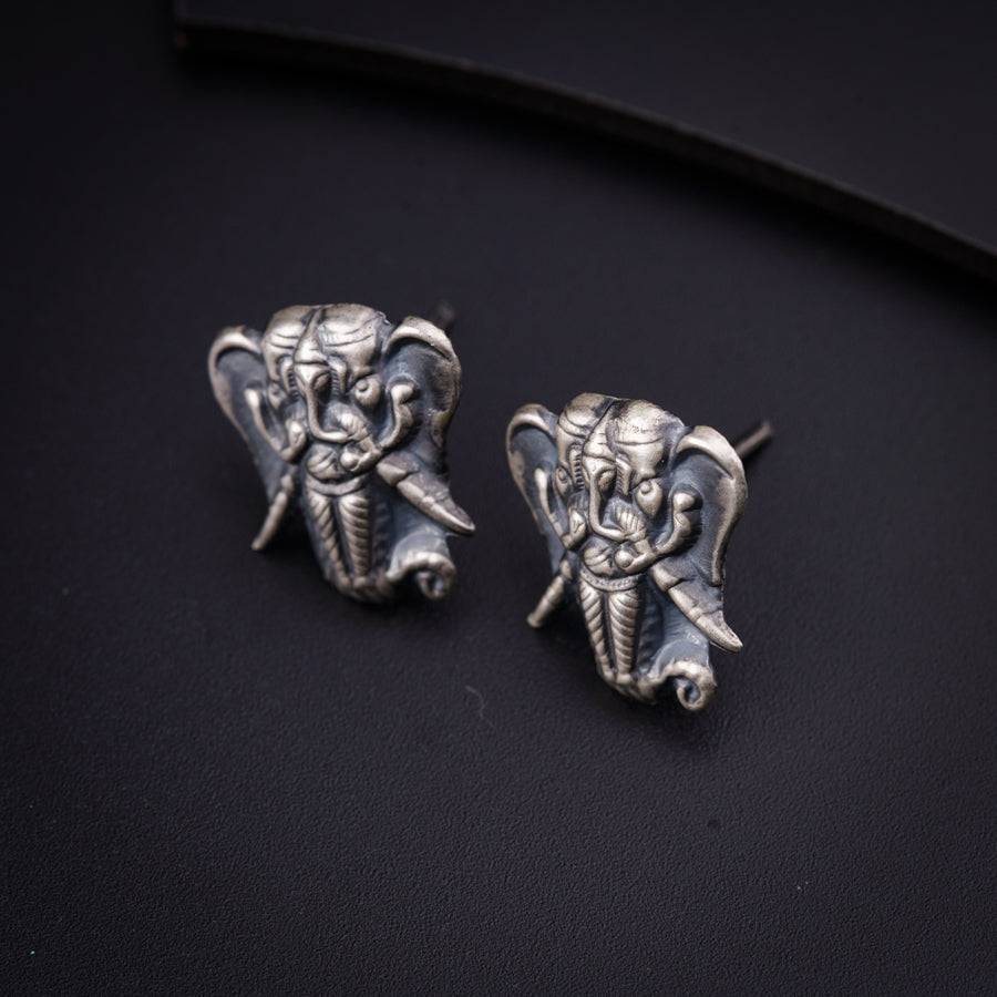 a pair of silver elephants sitting on top of a black surface