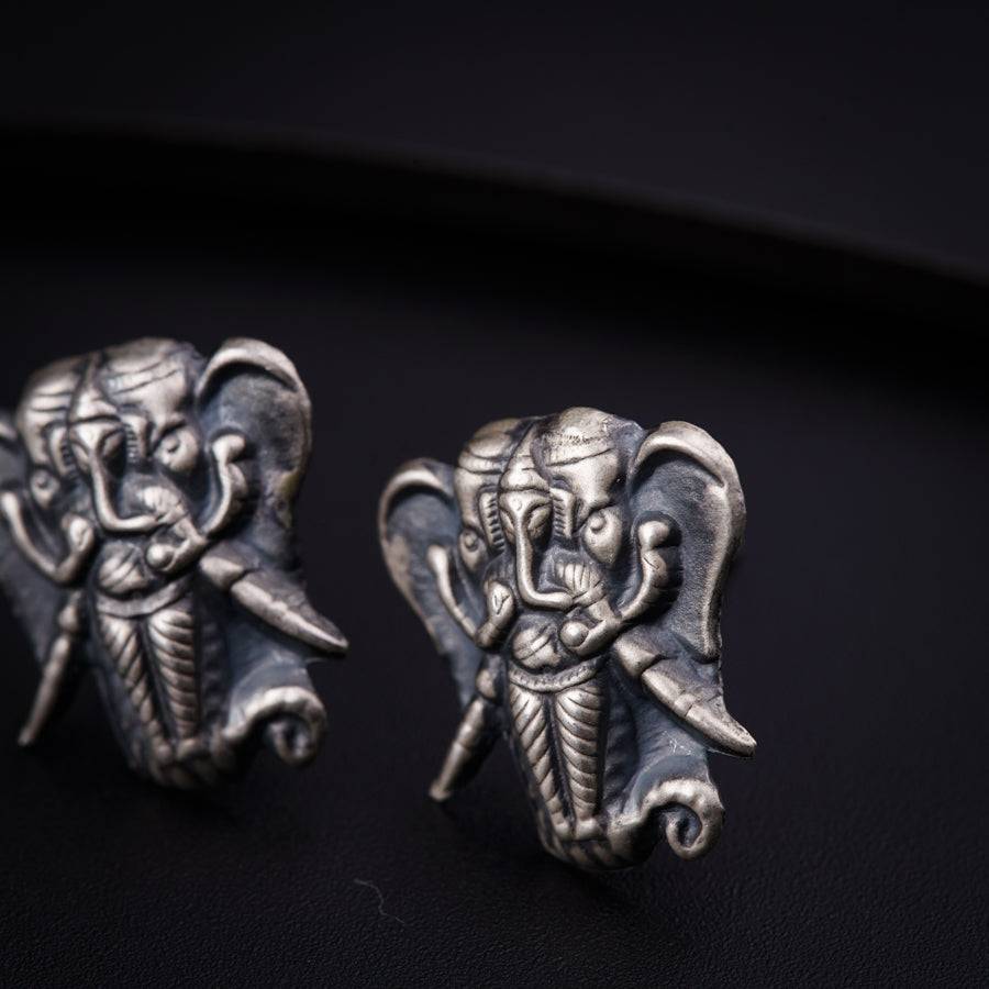 a pair of elephant head earrings sitting on top of a table