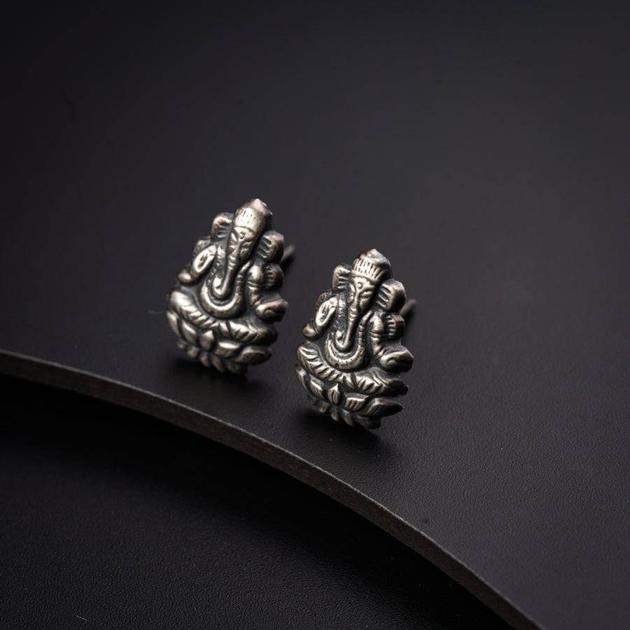a pair of silver earrings with an elephant design