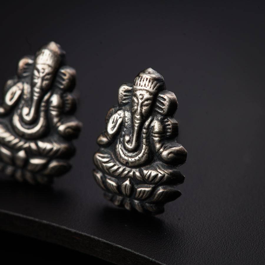 a pair of silver earrings with an elephant head