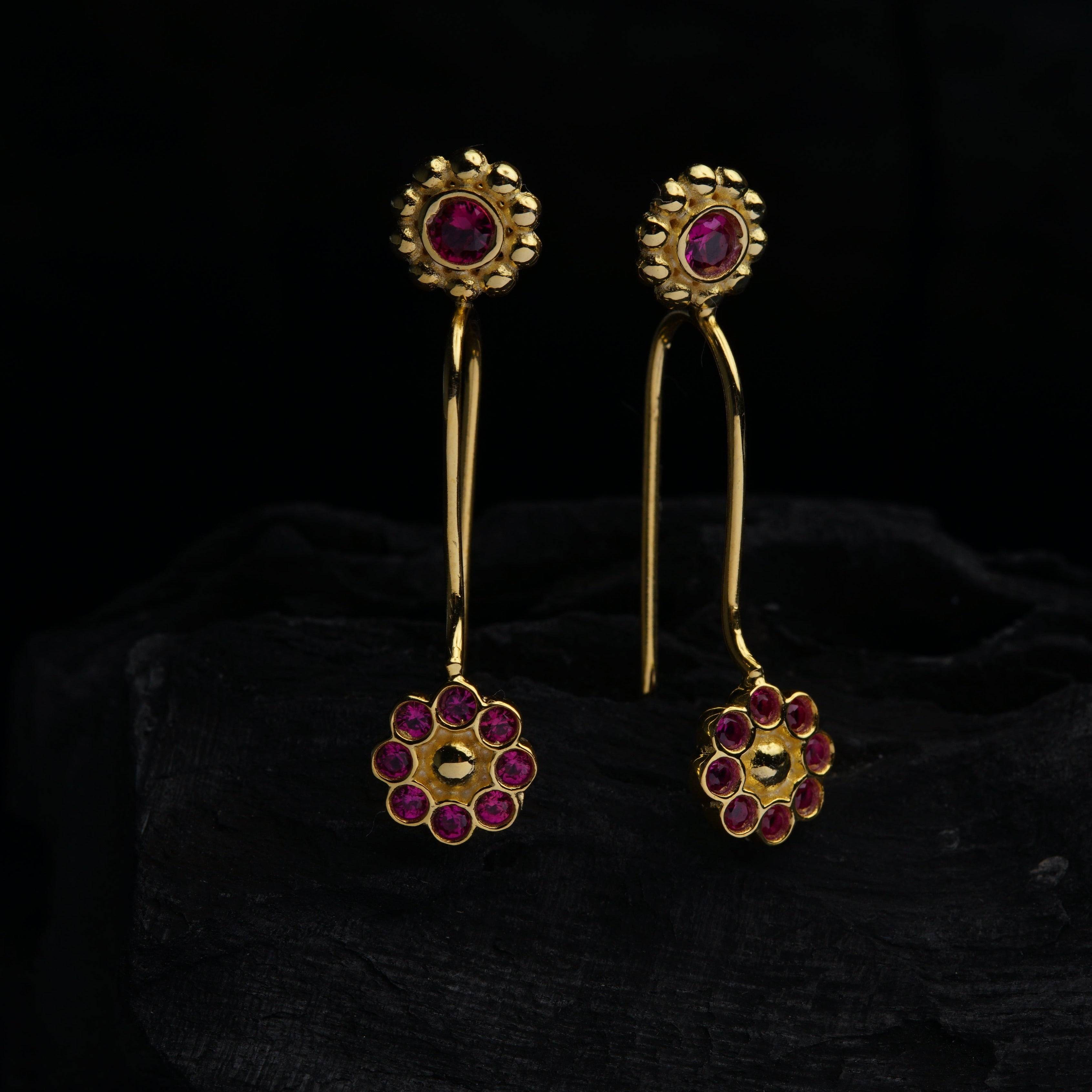 a pair of gold and ruby earrings