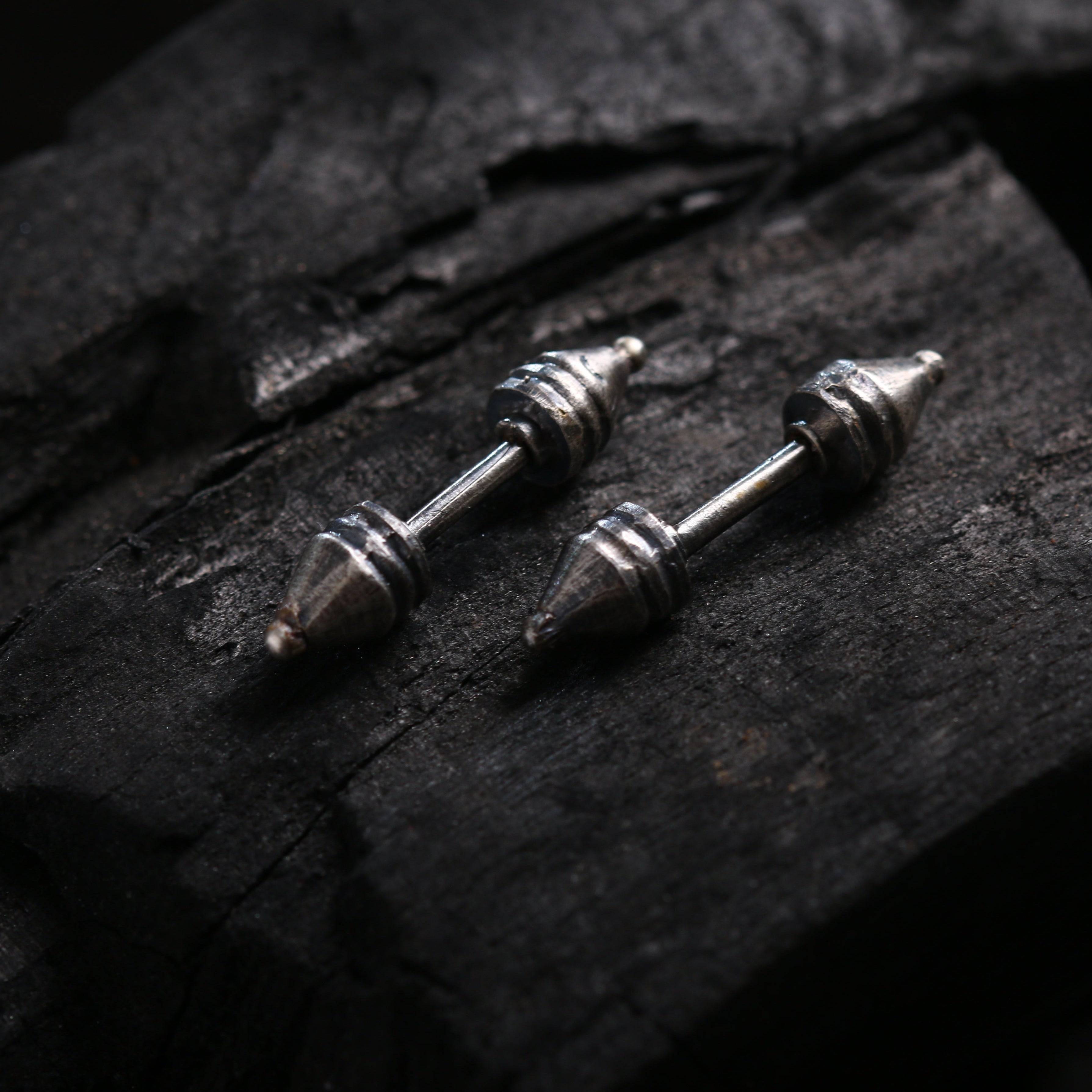 a pair of screws sitting on top of a piece of wood