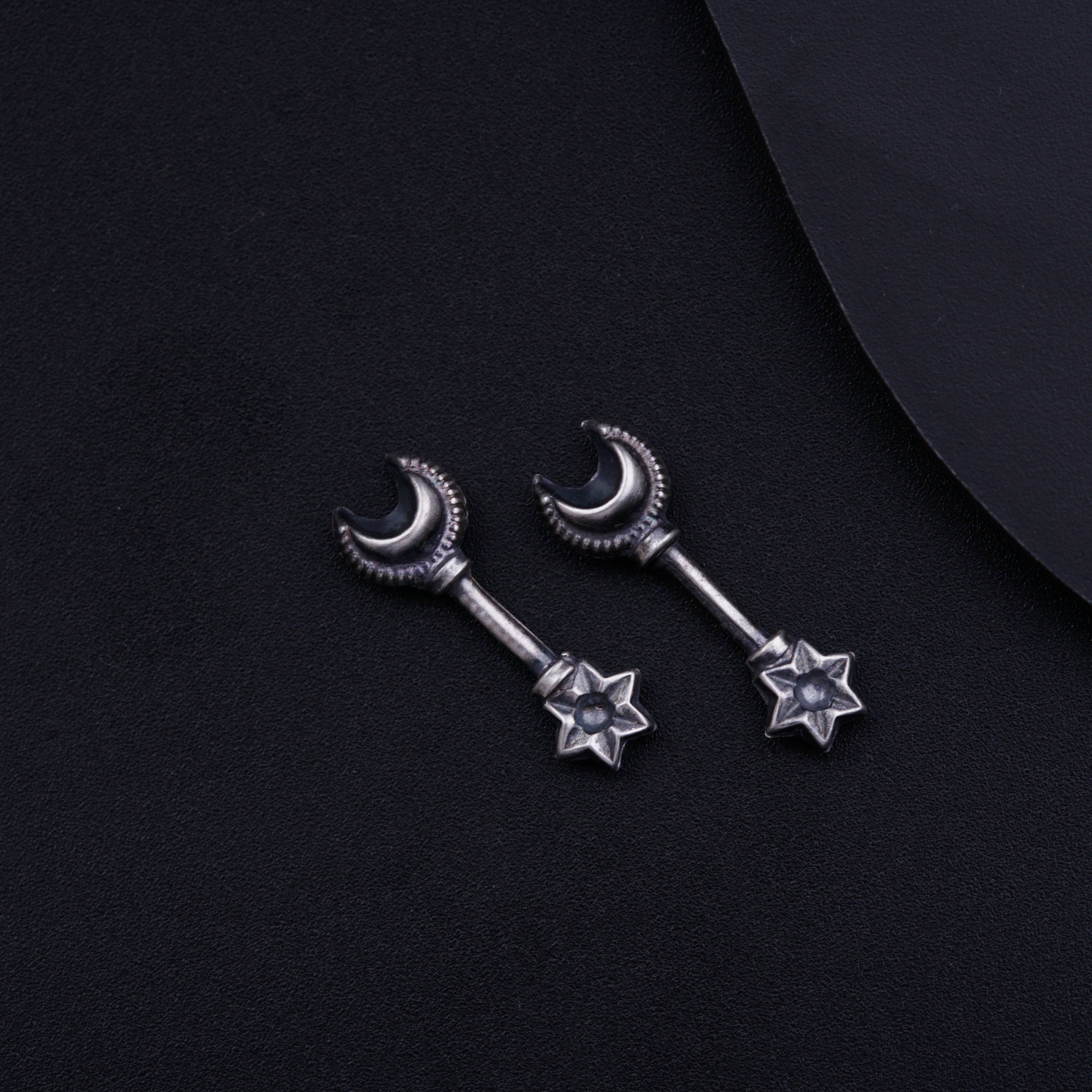 a pair of silver stars and moon earrings