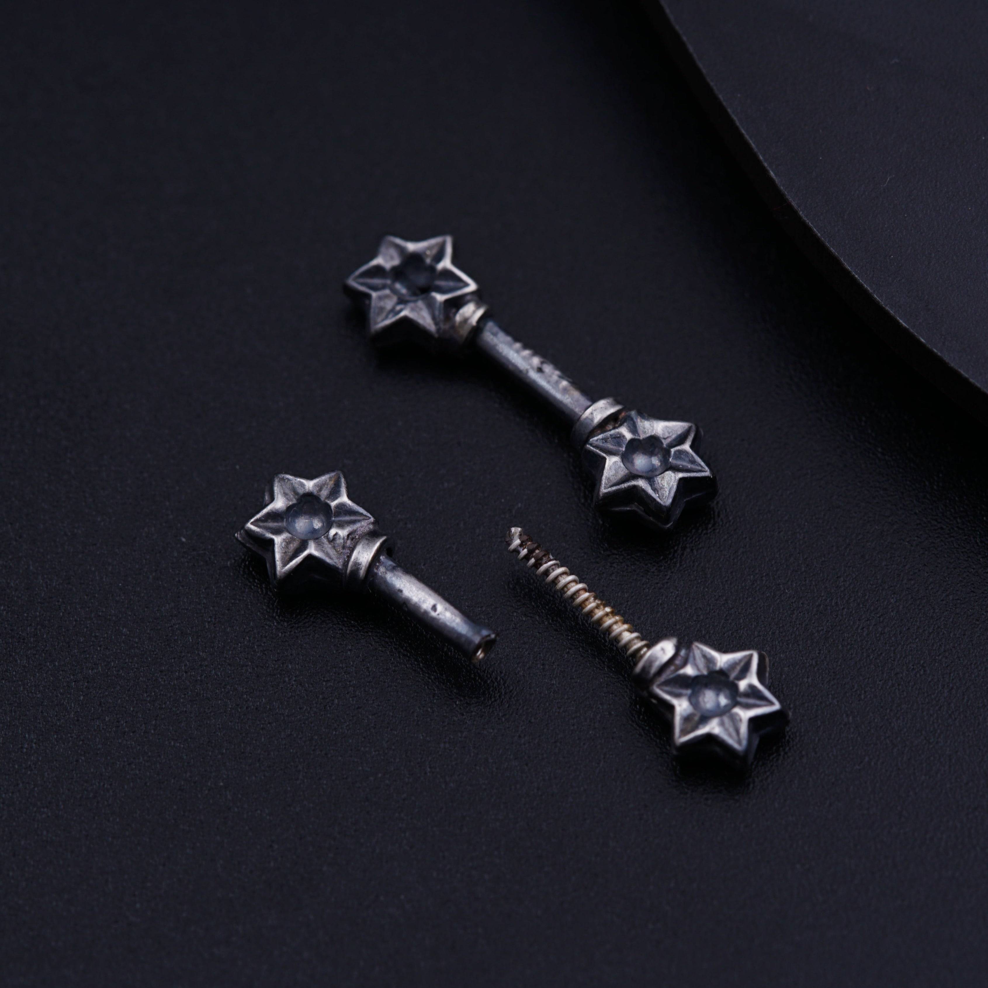 a pair of screws sitting on top of a black surface