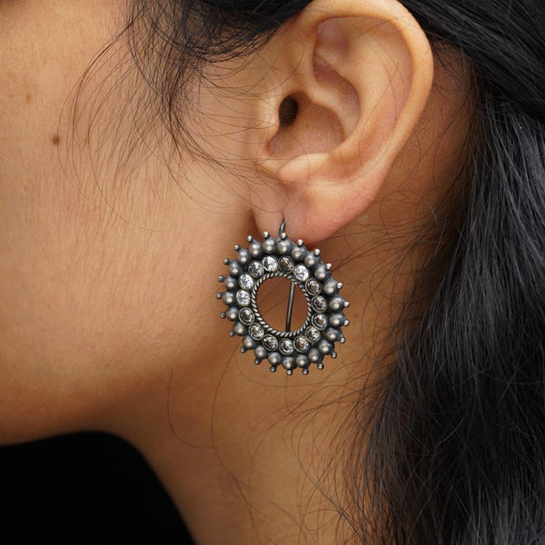 a close up of a person wearing a pair of earrings