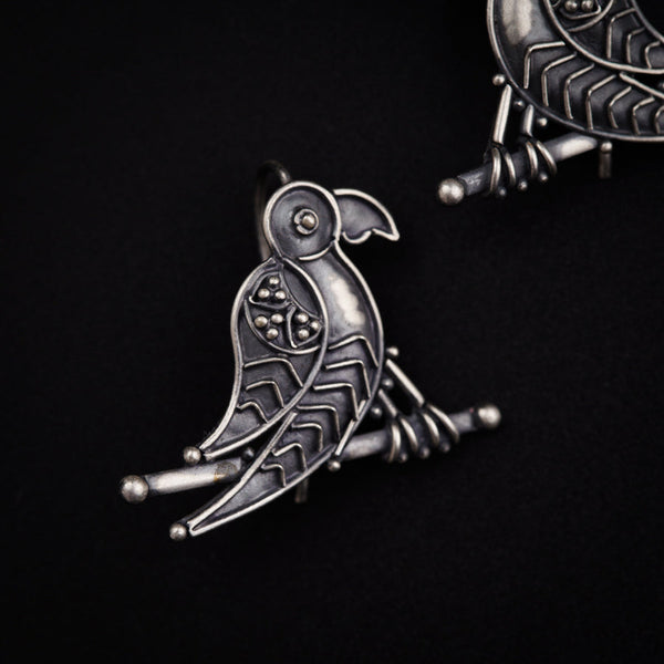 a pair of earrings with a bird on it