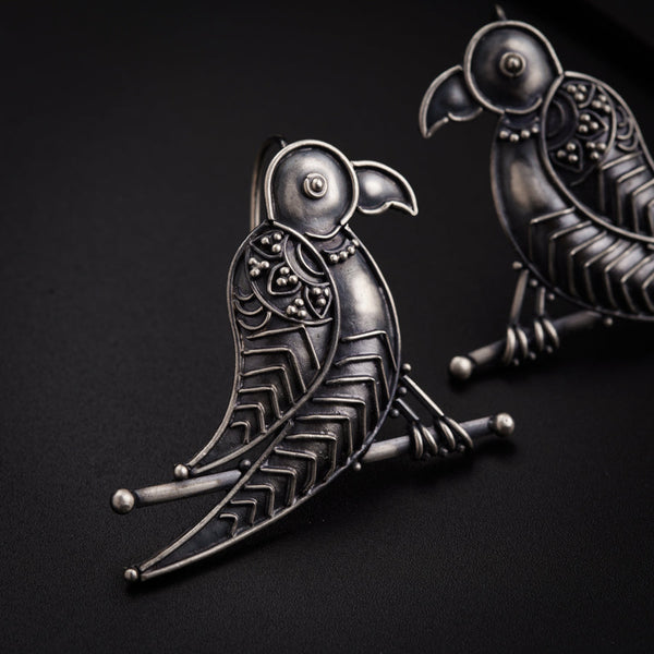 a pair of metal birds sitting on top of a table