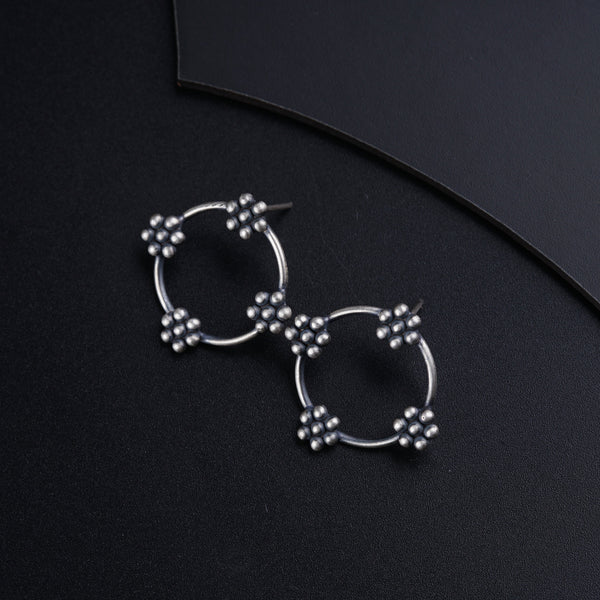 a pair of earrings sitting on top of a black surface