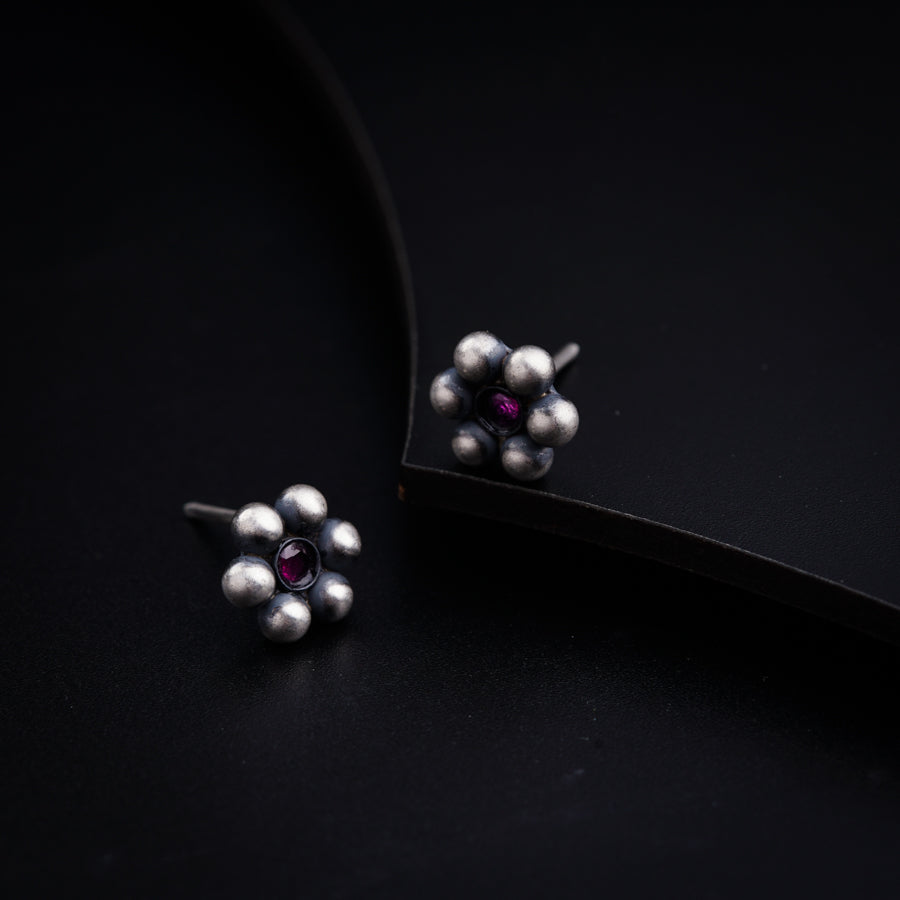 a pair of earrings with pearls and a rub